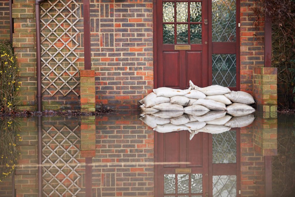 sandbags stacked out side of entryway protecting home from floodwaters
